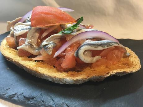 Tostas de pan payes con tomate escaldado y boquerones con sal maldón