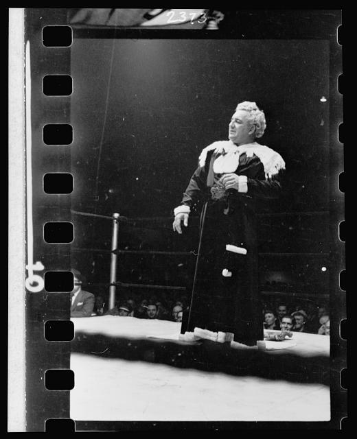 28. Gorgeous George, full-length portrait, standing in wrestling ring, facing left