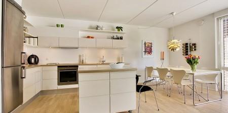 Un apartamento en blanco y lleno de muebles de diseño sillas 7 arne jacobsen fritz hansen muebles de diseño lámparas de diseño futbolín en el salón estilo nórdico estilo escandinavo estilo danés estanterías montana espacios diáfanos diseño danés decoración en blanco cocinas modernas cocinas blancas