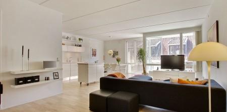 Un apartamento en blanco y lleno de muebles de diseño sillas 7 arne jacobsen fritz hansen muebles de diseño lámparas de diseño futbolín en el salón estilo nórdico estilo escandinavo estilo danés estanterías montana espacios diáfanos diseño danés decoración en blanco cocinas modernas cocinas blancas
