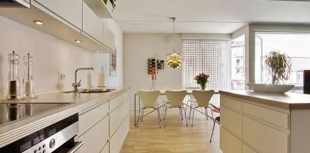 Un apartamento en blanco y lleno de muebles de diseño sillas 7 arne jacobsen fritz hansen muebles de diseño lámparas de diseño futbolín en el salón estilo nórdico estilo escandinavo estilo danés estanterías montana espacios diáfanos diseño danés decoración en blanco cocinas modernas cocinas blancas