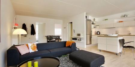 Un apartamento en blanco y lleno de muebles de diseño sillas 7 arne jacobsen fritz hansen muebles de diseño lámparas de diseño futbolín en el salón estilo nórdico estilo escandinavo estilo danés estanterías montana espacios diáfanos diseño danés decoración en blanco cocinas modernas cocinas blancas