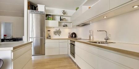 Un apartamento en blanco y lleno de muebles de diseño sillas 7 arne jacobsen fritz hansen muebles de diseño lámparas de diseño futbolín en el salón estilo nórdico estilo escandinavo estilo danés estanterías montana espacios diáfanos diseño danés decoración en blanco cocinas modernas cocinas blancas