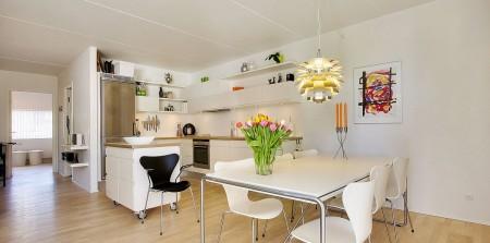Un apartamento en blanco y lleno de muebles de diseño sillas 7 arne jacobsen fritz hansen muebles de diseño lámparas de diseño futbolín en el salón estilo nórdico estilo escandinavo estilo danés estanterías montana espacios diáfanos diseño danés decoración en blanco cocinas modernas cocinas blancas