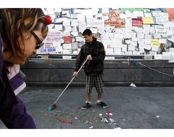 DEMOCRACIA REAL, YA! Demonstrators sweep the floor of a camp at Madrid's famous landmark Puerta del Sol