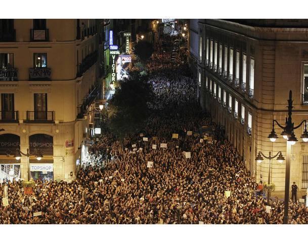 DEMOCRACIA REAL, YA! Demonstrators raise their arms just after midnight as they fill up Madrid's Puerta del Sol, spilling into sidestreets during the sixth day of protests