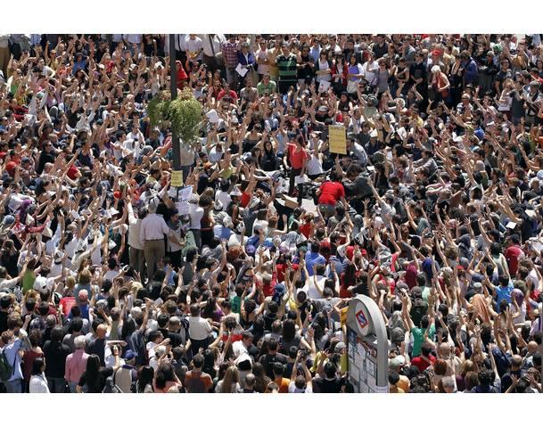 DEMOCRACIA REAL, YA! Demonstrators raise their arms during a protest against politicians, bankers and the economic crisis in Madrid's Puerta del Sol
