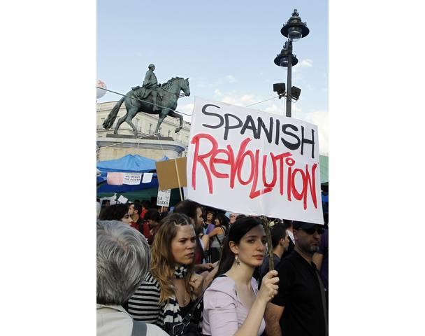 DEMOCRACIA REAL, YA! A demonstrator holds up a banner in Madrid's Puerta del Sol