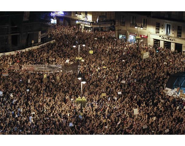 DEMOCRACIA REAL, YA! Demonstrators raise their arms just after midnight as they fill up Madrid's Puerta del Sol during the sixth day of protests