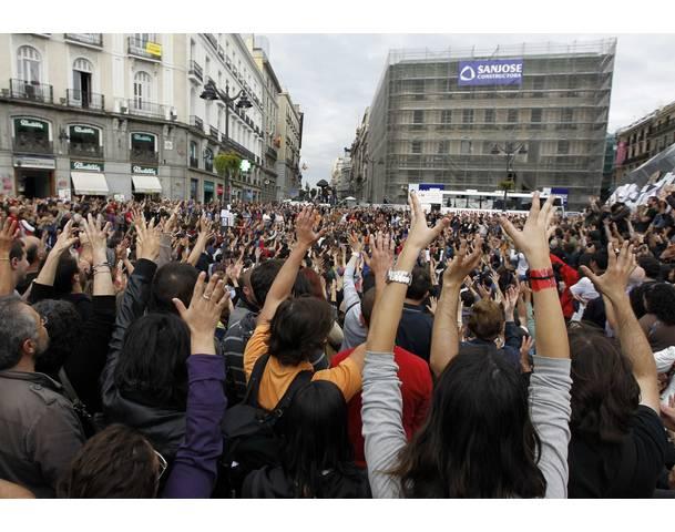 DEMOCRACIA REAL, YA! Demonstrators raise their arms in Madrid's Puerta del Sol