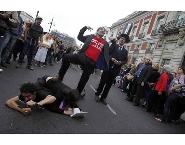 DEMOCRACIA REAL, YA! Demonstrators carry out a political skit in Madrid's famous landmark Puerta del Sol