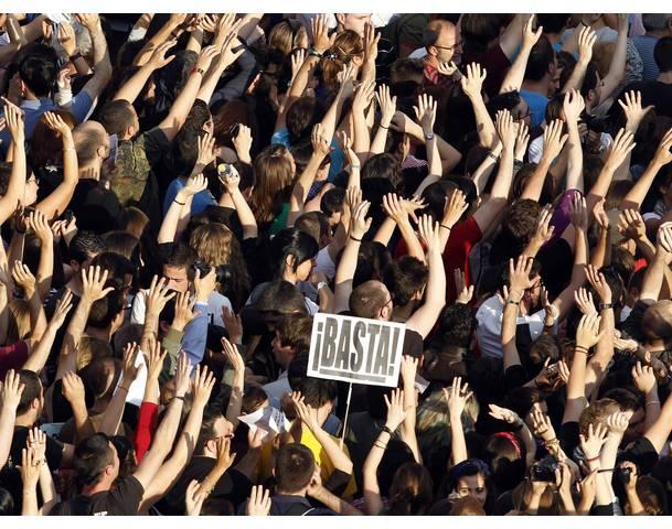 DEMOCRACIA REAL, YA! Demonstrators raise their arms in Madrid's Puerta del