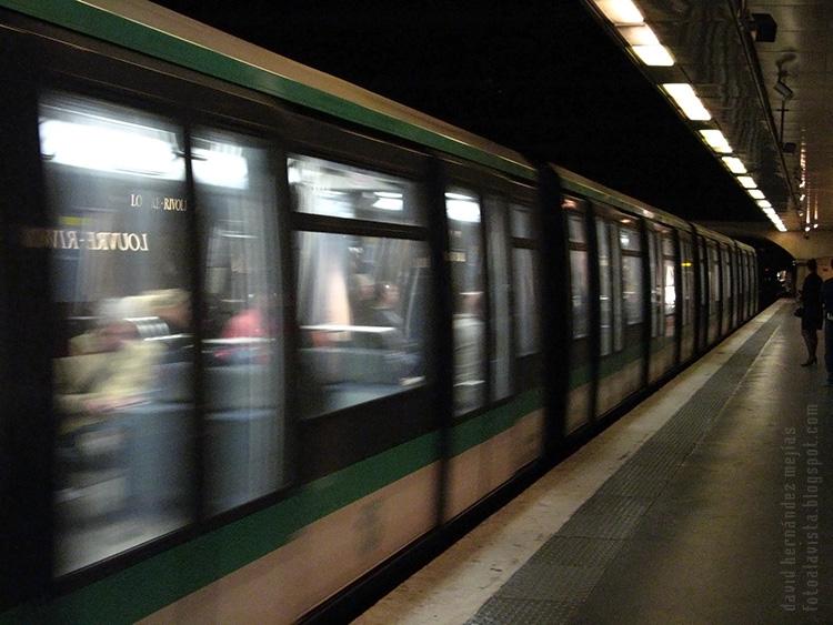 Un tren de metro pasa por una estación de París, Francia, mientras algunas personas esperaban en el anden
