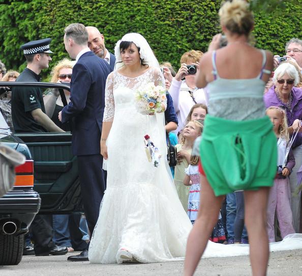 Lily Allen THE HAPPY COUPLE! Lily Allen and Sam Cooper emerge from St James The Great Church in Cranham after their wedding. Lily was wearing a Chanel lace dress created by Karl Lagerfeld and was looking estatically happy following her marriage to Sam.  The singer-turned-businesswoman was carrying a bouquet with a knitted bride and groom hanging from the stems.
