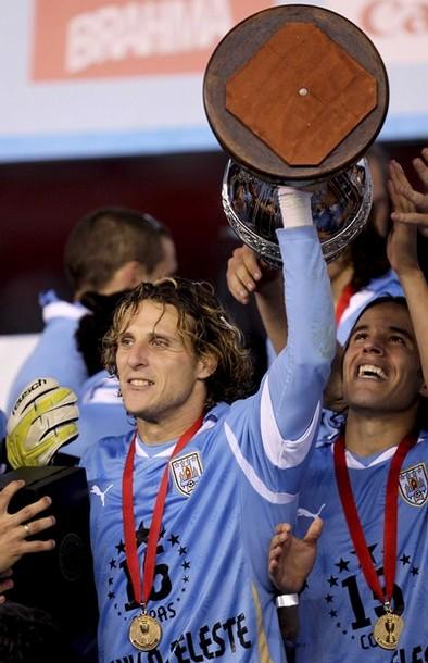 Uruguay's Forlan holds the trophy with teammates after winning the Copa America final soccer match against Paraguay in Buenos Aires Quisiera que esto dure para siempre