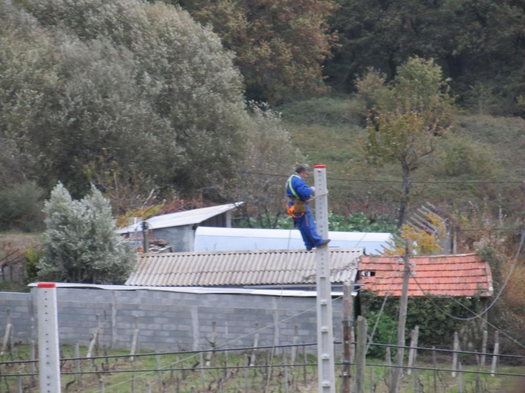 Trabajador desempeñando sus labores al tope de un poste de hormigón