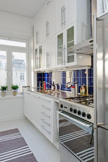 Una cocina abierta al salón taburetes tolix muebles de ikea estilo sueco decoración estilo nórdico decoración pisos pequeños decoración interiores deconración interiores pequeños cocinas blancas cocina moderna cocina diáfana abierta al salón chandelier apartamento sueco