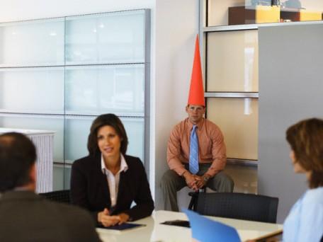 Business meeting with dunce sat in corner Business meeting with dunce sat in corner