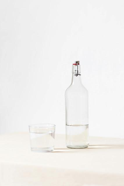 Botella de vidrio junto a un vaso Botella de vidrio junto a un vaso