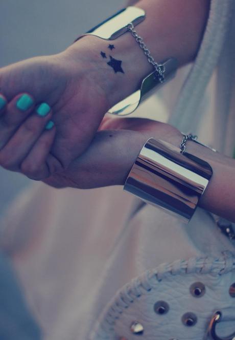 Silver bracelets like cuffs and studded bag in a fashion blog
