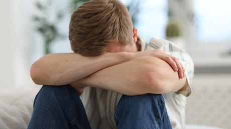 Guía para confesar tu lucha sexual sin morir en el intento Hombre joven orando con angustia buscando libertad del pecado sexual y la pornografía.