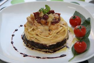 Linguine sobre cama de cebolla caramelizada al Oporto, coronados con una crema de manzana y confit de pato, finalizados con una reducción de Oporto