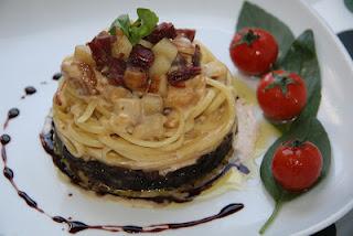 Linguine sobre cama de cebolla caramelizada al Oporto, coronados con una crema de manzana y confit de pato, finalizados con una reducción de Oporto