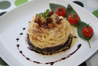 Linguine sobre cama de cebolla caramelizada al Oporto, coronados con una crema de manzana y confit de pato, finalizados con una reducción de Oporto