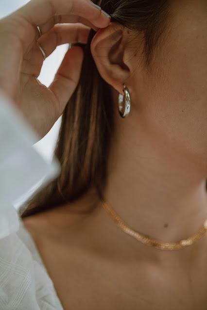 Mujer mostrando su oreja con un pendiente de aro Mujer mostrando su oreja con un pendiente de aro
