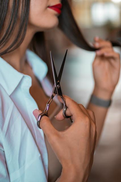 Mujer con unas tijeras en la mano haciendo el gesto de ir a cortarse el cabello