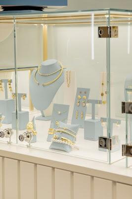 Nuevo concepto de tienda abierta y experiencial de Luxenter en Centro Oeste, joyería de diseño accesible con mostradores minimalistas de madera clara e iluminación cálida contemporánea.