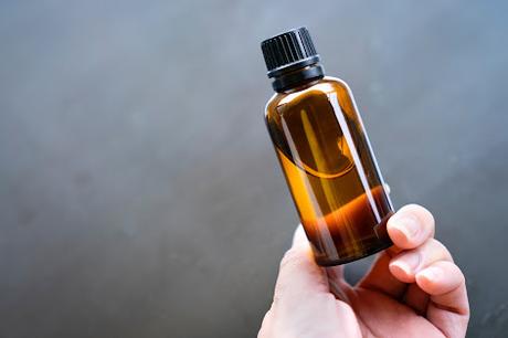 Mano sosteniendo un frasco de aceite Mano sosteniendo un frasco de aceite