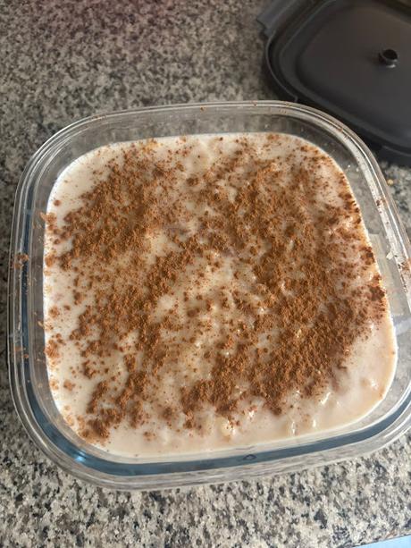 Recipiente de arroz con leche casero muy cremoso espolvoreado con canela por encima hecho en microondas