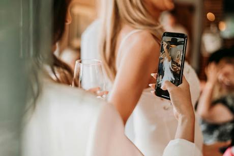 Mujer grabando con su teléfono a la novia mientras baila Mujer grabando con su teléfono a la novia mientras baila