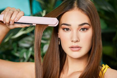 Mujer pasando la plancha por su cabello Mujer pasando la plancha por su cabello
