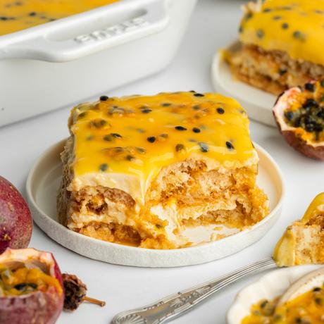 Tiramisú de maracuyá vegano en fuente de vidrio con cobertura brillante de semillas de maracuyá