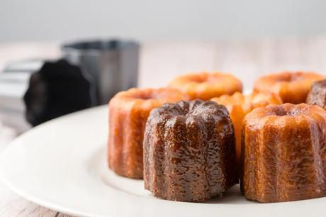 Detalle de los Canelés de Burdeos con su molde al fondo