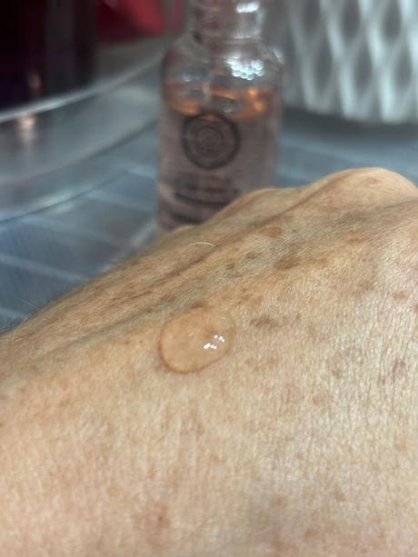 Muestra de la textura fluida del sĂŠrum de vitamina C de Natura Siberica sobre la piel.