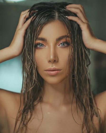 Mujer tocándose la melena, con el cabello húmedo