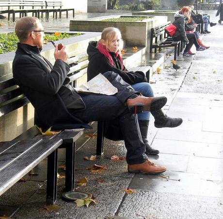 father smoking pipe and daughter sitting marble arch London wet weather 7th January 2011 13:55.05pm