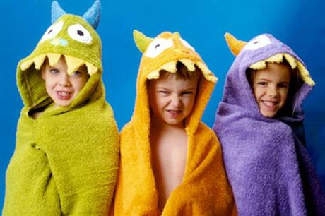 tres niños con toallas de monstruos