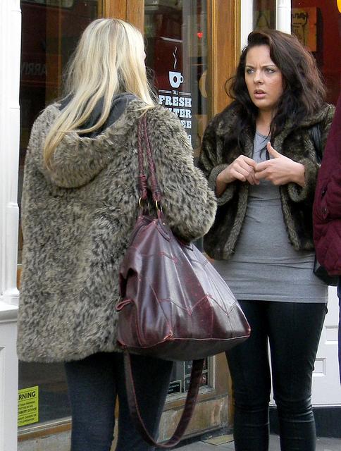 two women blonde brunette talking standing piccadilly London 24th February 2011 13:02.06pm