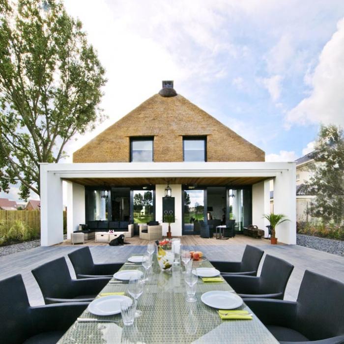 Arjen-Reas-Zoetermeer-thatched-roof-walls-lime-walls-wood-deck-outdoor-table-chairs