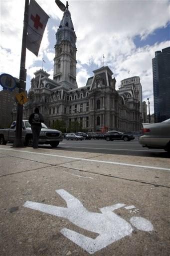 Foto del 2 de abril del 2012 de una acera frente al ayuntamiento de Filadelfia. El alcalde Michael Nutter dijo que los transeuntes distraídos corren más peligro en la calzada debido a que los conductores no siempre prestan atención. (© Foto AP/Matt Rourke)