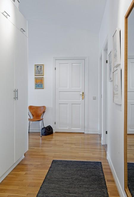 ventana redondeada suelo de parquet sofá gris sillas eames muebles blancos decoración limpieza en ático diáfano estilo nórdico estilo escandinavo electrodomésticos silenciosos decorar pisos decorar con muebles de ikea decoración estilo nórdico decoración escandinava decoración diáfana decoración de áticos cocina blanca blog deco blog de interiorismo blog de decoración ático diáfano 