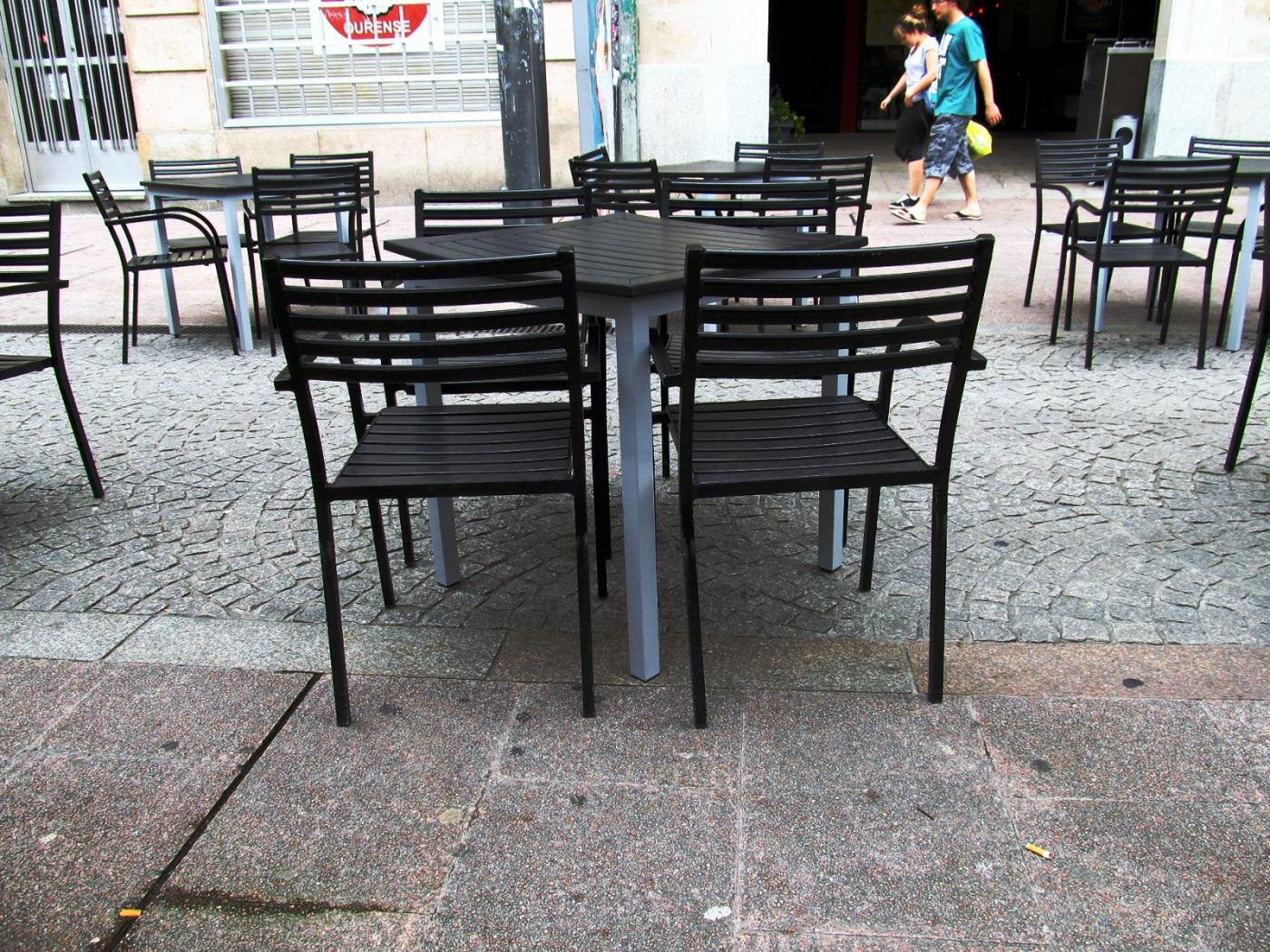 Terraza veraniega de una franquicia internacional de hamburguesas; el interior del local, también vacío