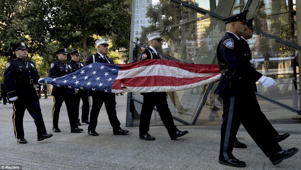 Sombre: Port Authority Police Officers carry the U.S. flag that flew at the World Trade Center towers during ceremonies marking the 9/11 attacks