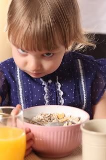 Niña comiendo cereales enfadada