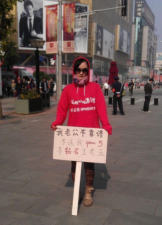 Una mujer protesta en las calles de Beijing pues el marido no le quiere comprar un iPhone 5 #WTF