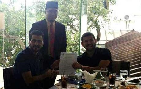 Güiza -izquierda-, mostrando su contrato junto al presidente del Johor